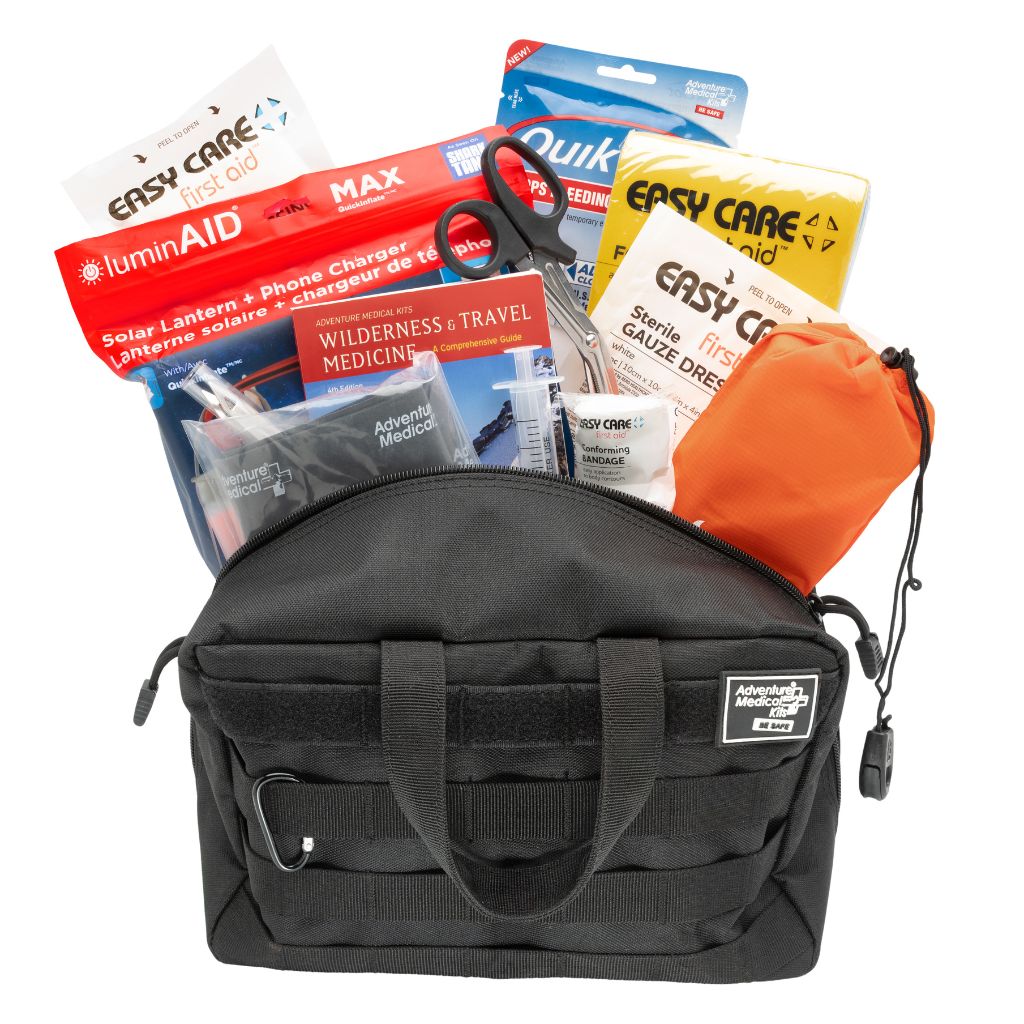 MOLLE Pro black bag with emergency supplies including bandages, scissors, and a solar lantern on a white background