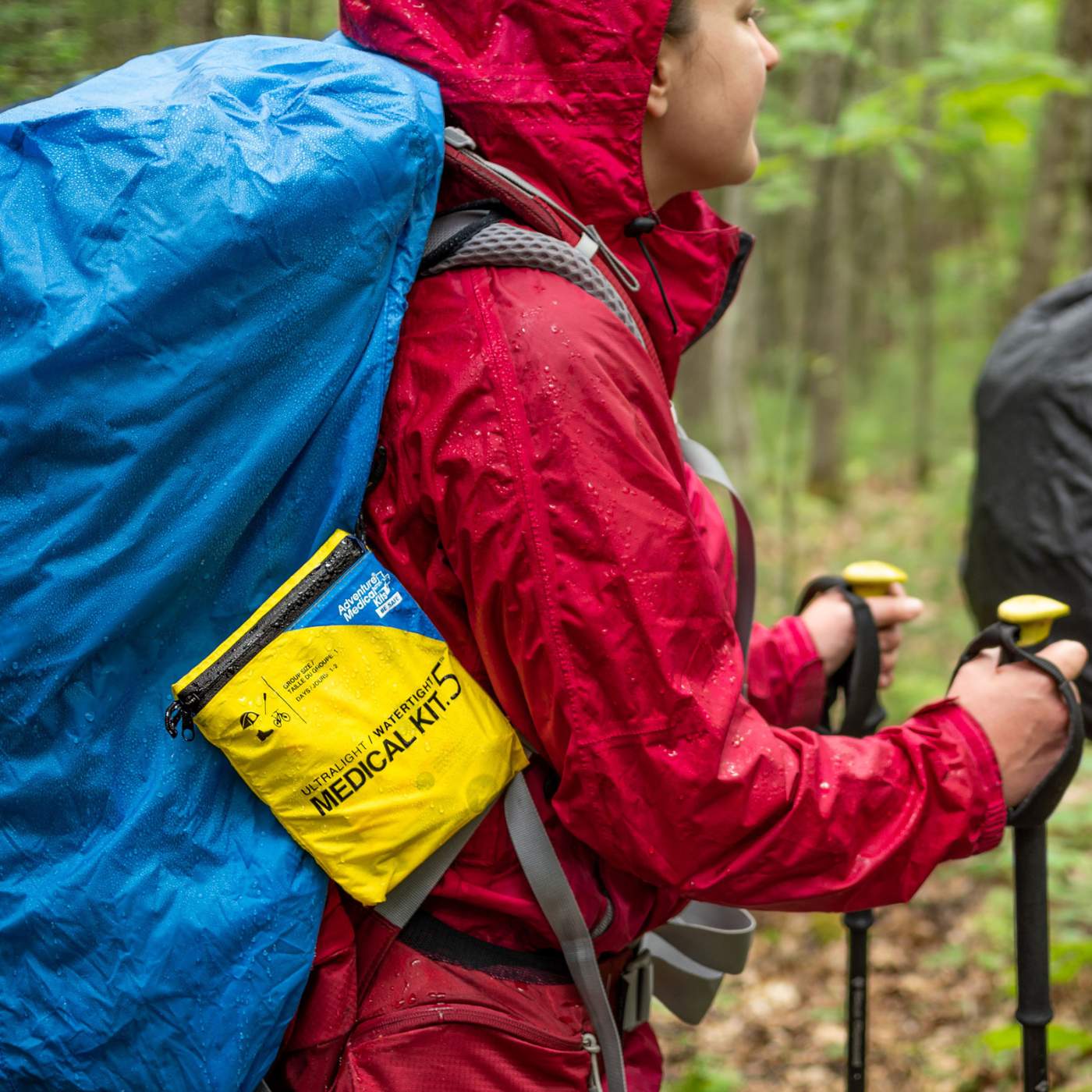 Ultralight Watertight .5 kit on hiker in rain with hiking poles