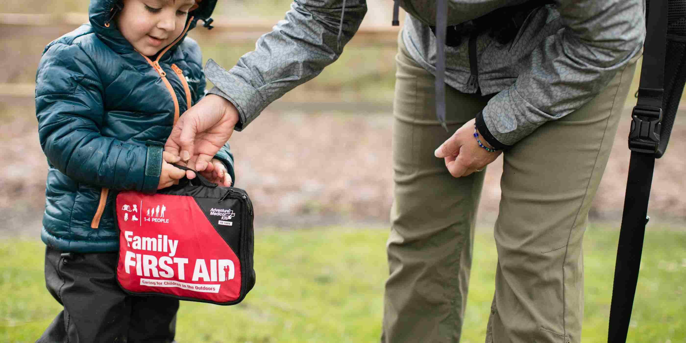 Adventure First Aid, Family First Aid Kit person and child holding kit outside