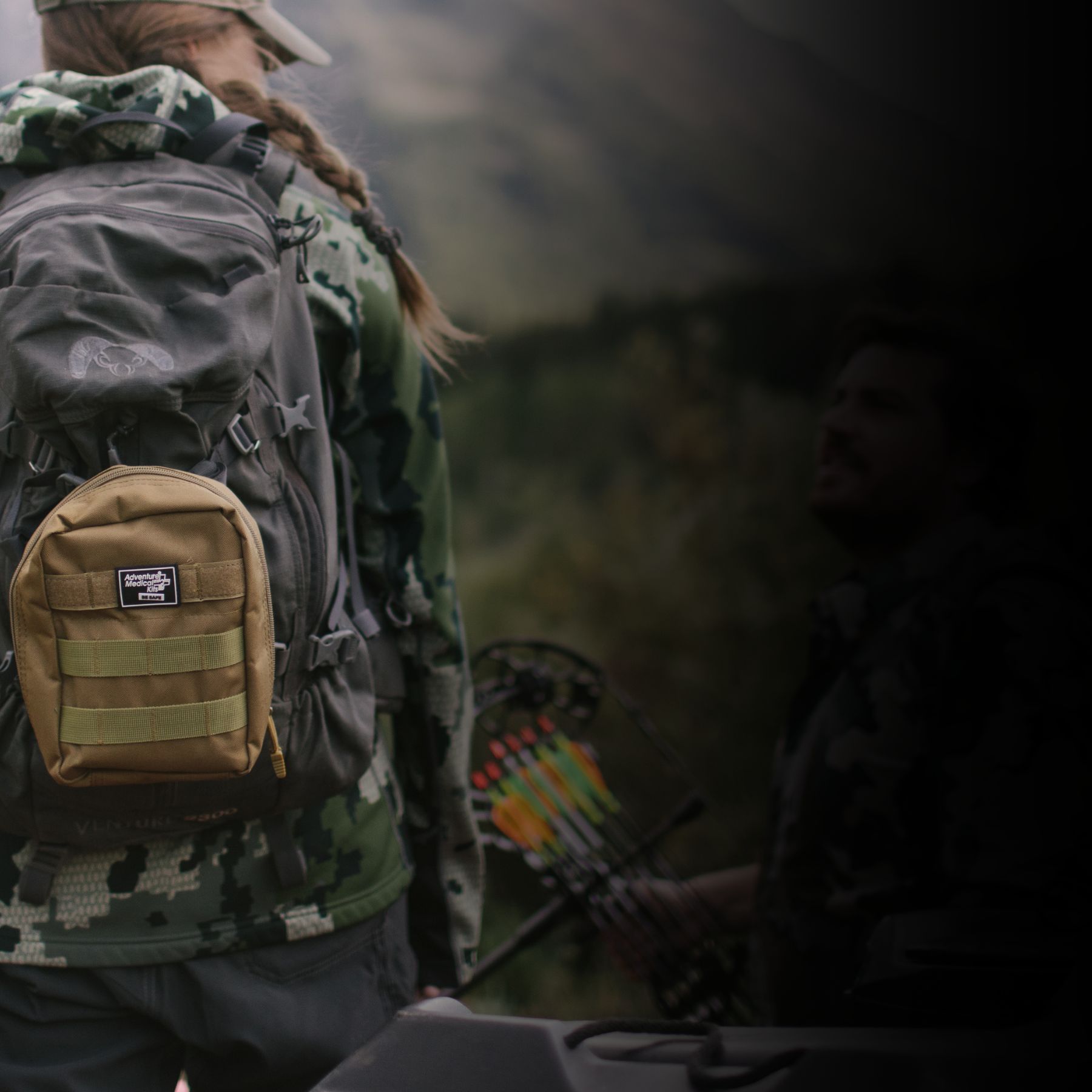 Woman in camo with MOLLE kit on backpack