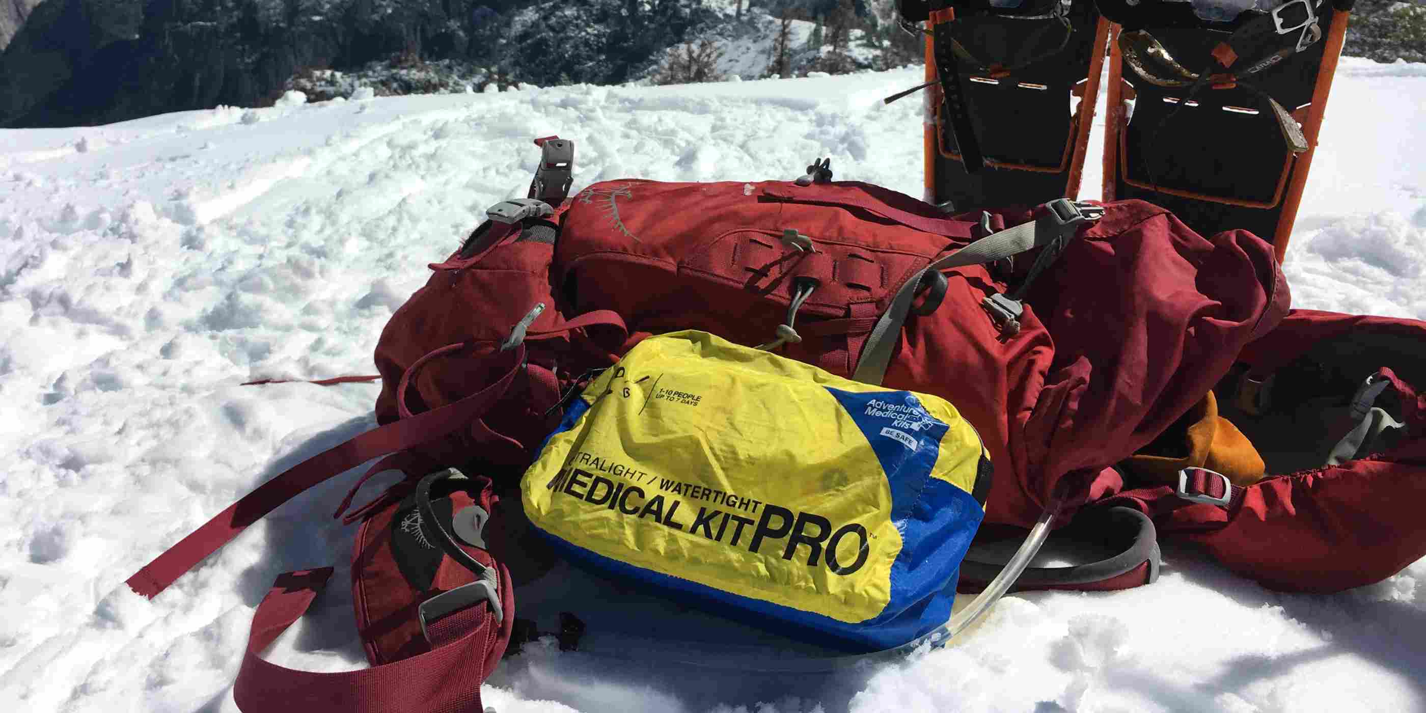 Ultralight/Watertight Medical Kit - Pro next to backpack and snowshoes in the snow