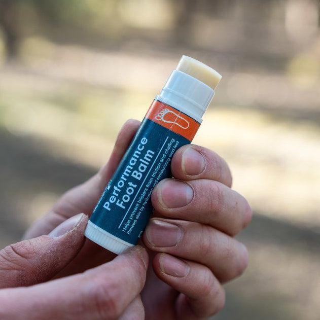 performance foot balm being dispensed in hands 