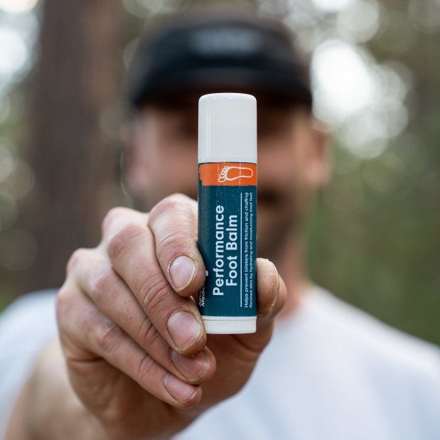 foot balm being held in front of adult face